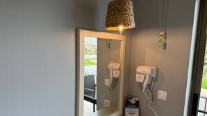 A bathroom with a mirror, a hairdryer, and a towel rack.