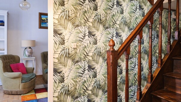 A staircase with a wooden handrail and a tropical leaf wallpaper. - Warm and Authentic! The watchmaker’s house, downtown Crozon (Crozon)