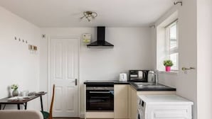 A compact kitchen with a built-in oven, a microwave, and a sink. - Kingston Richmond Lux Brand new Studio (Kingston Upon Thames)