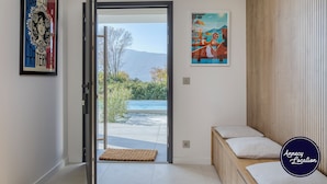 Une pièce comprenant un lit, une porte donnant sur l’extérieur et deux œuvres d’art encadrées accrochées aux murs.