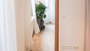 A hallway with wooden flooring, white walls, and a potted plant. - Beautiful apartment in Liège center - 1st floor (Liège)