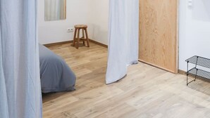 A minimalist bedroom with a wooden door, a small stool, and a metal shelf. - Beautiful apartment in Liège center - 1st floor (Liège)