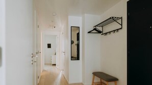 A hallway with a bench, a coat rack, and a mirror on the wall. - Apt. 2 chambres + garage en plein centre de Liege (Liège)