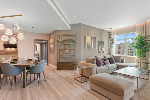A modern living room with a dining area, featuring a sofa set, a coffee table, and a dining table with chairs.