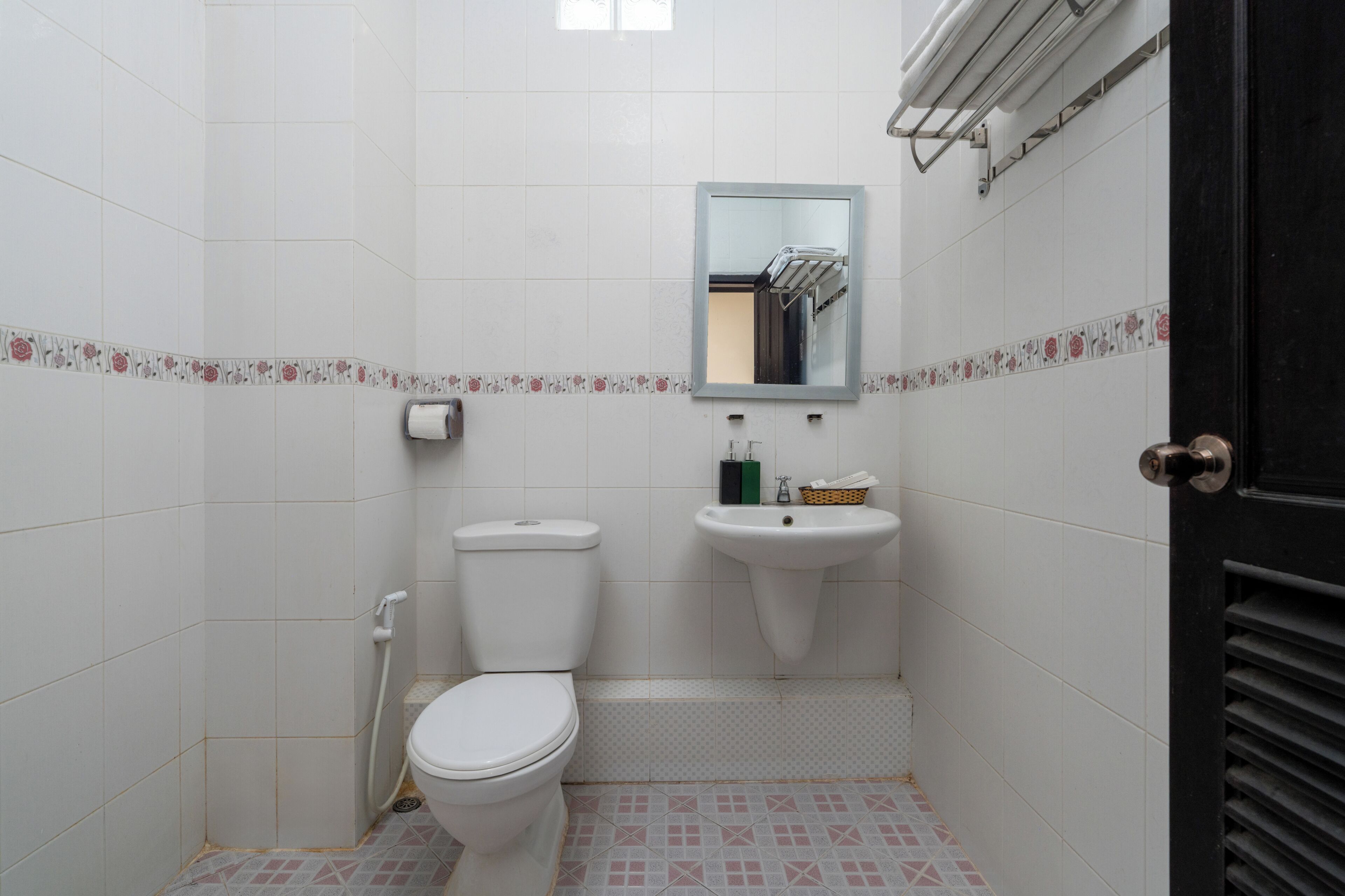 A small bathroom with a toilet, sink, and mirror.