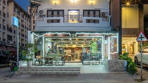 A multi-story hotel with balconies, a ground-level shop, and a sign for 'Hotel Boutique.' - Lucky City Hotel (Vientiane)