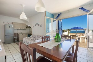 Uma cozinha moderna com geladeira, armários de madeira e um espaço de refeições com mesa e cadeiras.