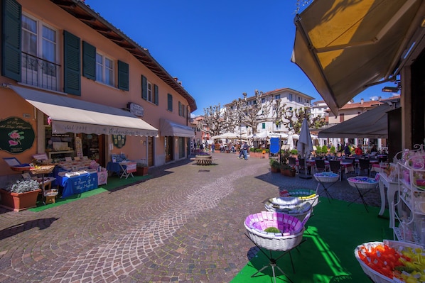 A cobblestone street with shops and outdoor seating areas.