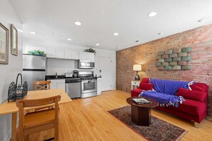 A compact living space with a kitchen, dining area, and a red sofa. - Charming Apt-Grandview Ave-Pittsburgh Iconic Views (Pittsburgh)