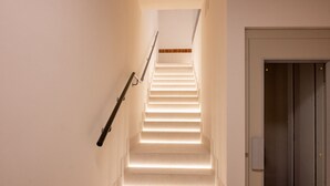 A staircase with illuminated steps leading to a landing. - Estudio Oriente - Design et confort dans DELICIAS MADRID (Madrid)