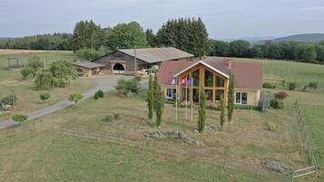 A rural property with a main house, a barn, and a fenced area.