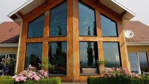 Une maison moderne dotée de grandes fenêtres et d’un toit en pente.
