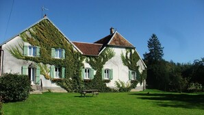 A house with a sloped roof, green shutters, and ivy covering part of the exterior walls. - Cozy room in historic house with park and horse facility (Choye)