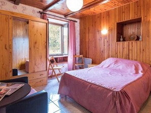 A wooden room with a bed, a table, and a chair. - Cosy Rose Room with kitchenette and terrace (Melin)