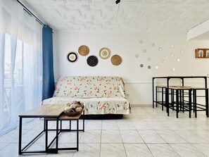 A modern living room with a sofa, a dining table, and a coffee table.