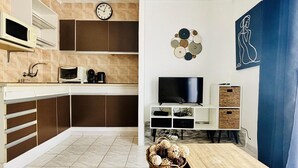 Eine moderne Küche mit Mikrowelle, Kaffeemaschine und Flachbildfernseher.