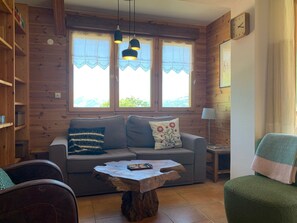 Une pièce chaleureuse avec un canapé, une table basse en bois et une lampe.