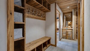 A hallway with wooden shelving units, a bench, and a mirror. - Arc 1950: 10 guests, 4 bdr, ski-in/ski-out (Les Arcs 1950)