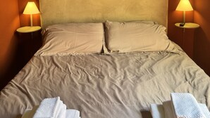 A bed with beige bedding, two bedside lamps, and folded towels on the bed. - VERONA EASY LOFT - ID M0230911208 (Verona)