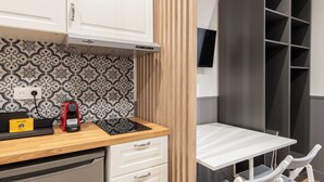 Una kitchenette compacta con estufa moderna, horno integrado y lavavajillas pequeño.