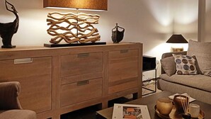 A modern living room with a wooden cabinet, a coffee table, and a sofa.