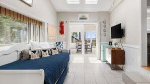 Quarto com cama, televisão e vista para o exterior.
