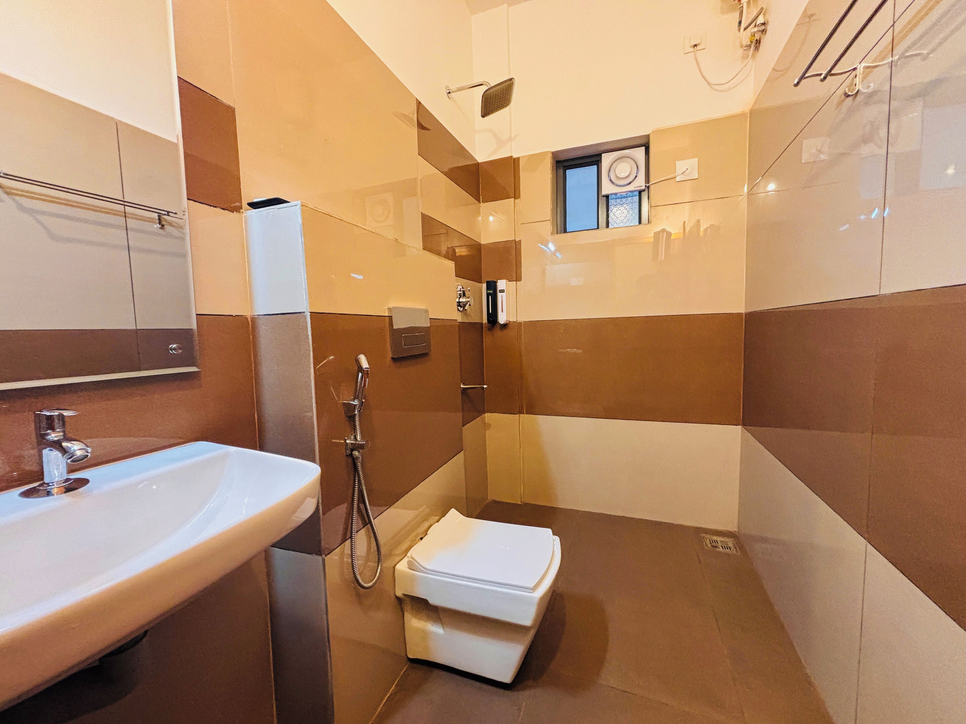 A modern bathroom with a sink, shower, and toilet.
