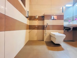 A modern bathroom with a shower, toilet, and sink. - Hunters Hideout Resort (Vythiri)