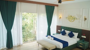A bedroom with a large bed, green curtains, a ceiling fan, and a clock on the wall. - Hunters Hideout Resort (Vythiri)