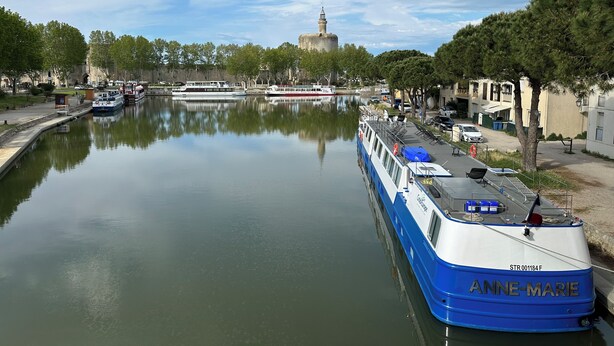 A calm river with a boat named "ANNE-MARIE" docked on the right. - Apartment with pool in the Camargue - family time in a great complex (Saint-Laurent-d'Aigouze)