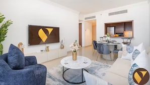 Una sala de estar moderna con un sofá, una mesa de centro y una zona de comedor con una mesa y sillas.