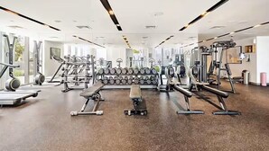 Un gimnasio moderno con diversos equipos de ejercicio, incluyendo cintas de correr, mancuernas y máquinas de pesas.