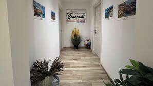 A hallway with a welcome sign, wooden flooring, and framed pictures on the walls. - al molo 21 (La Spezia)