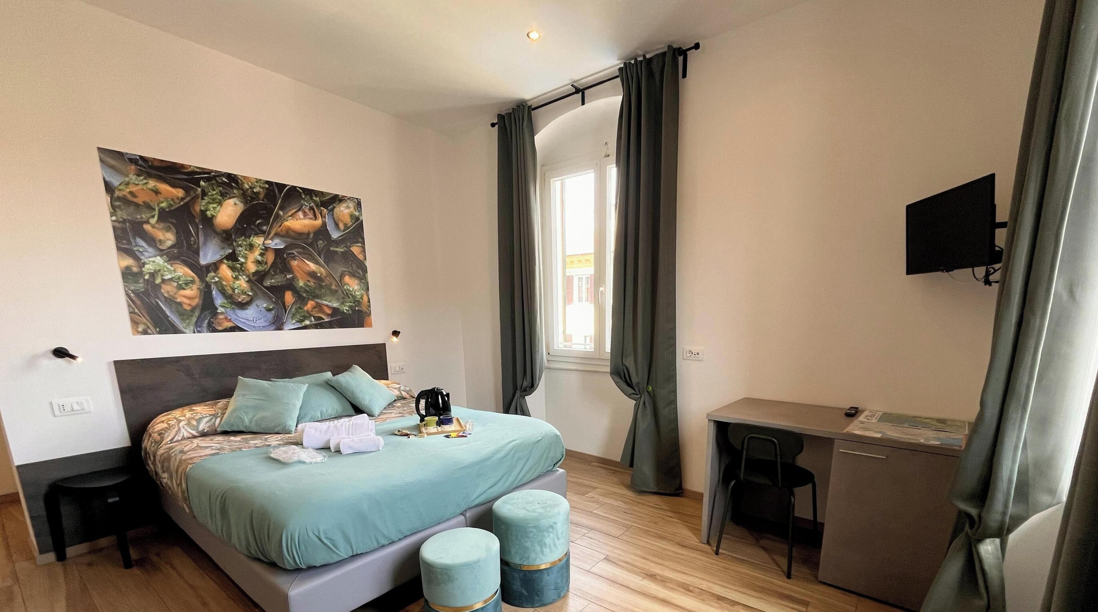 Ein Schlafzimmer mit einem Bett, einem Schreibtisch, einem Stuhl, einem Fernseher und einem Bild an der Wand.