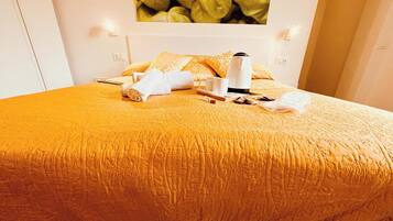 Una habitación de hotel con una cama, una mesita de centro, una taza blanca, otra taza blanca y una toalla blanca.