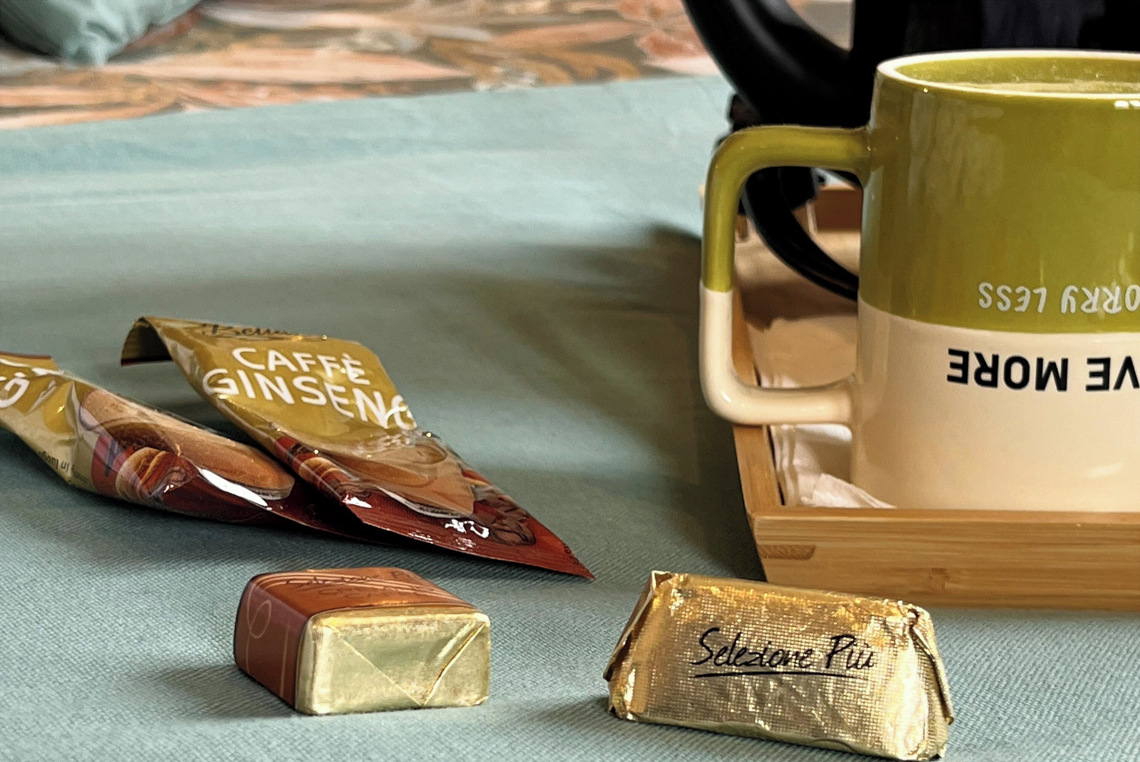 Un plateau avec une tasse et trois emballages de chocolat.
