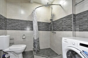 Apartamento Deluxe, vistas a la ciudad | Baño | Artículos de higiene personal gratuitos, secador de pelo y zapatillas