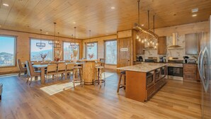 Une cuisine spacieuse dotée de planchers en bois, d’un îlot central et d’appareils électroménagers modernes.