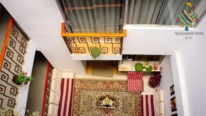 Un hall d’hôtel avec un tapis à motifs, un canapé et un mur décoratif.