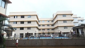 A multi-story residential building with a swimming pool in the foreground. - Antique Homestay Daman (Daman)