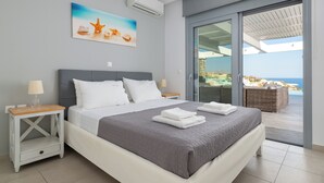 A bedroom with a bed, nightstands, a painting, and a view of the ocean. - Modern Luxury Villa in Vlicha (4347+W3Q Lindos, Greece)