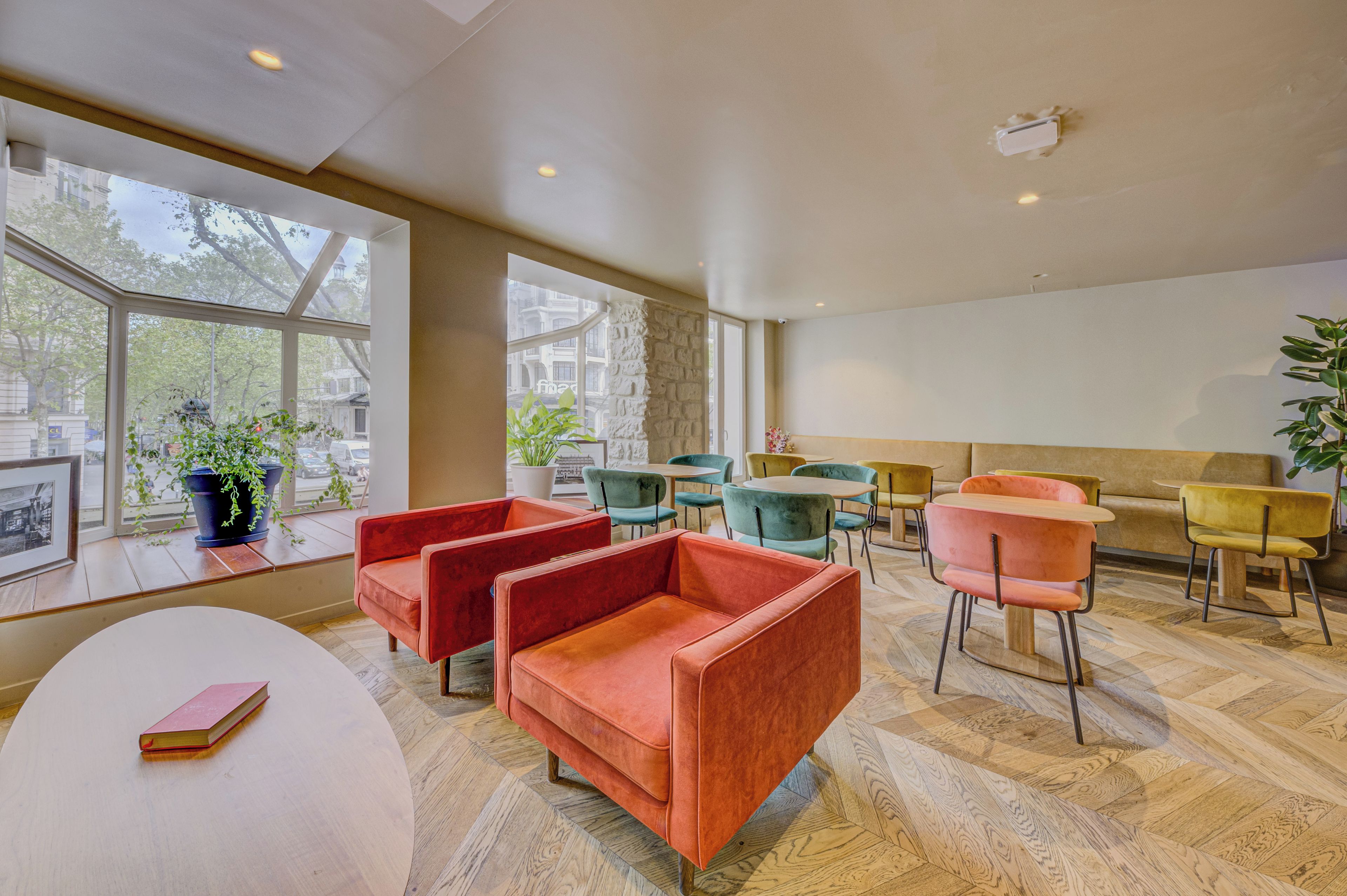 A modern interior with seating arrangements, large windows, and a view of the outside.