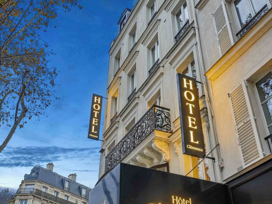 Un hotel llamado 'Hotel Clémence' con un estilo arquitectónico europeo clásico, con balcones y ventanas amplias.
