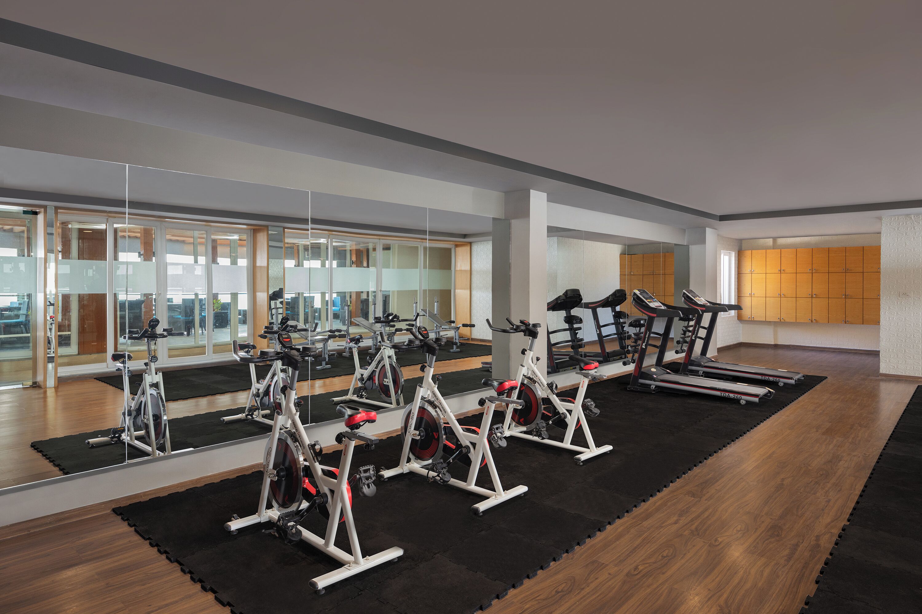 Un gimnasio con bicicletas estáticas, cintas de correr y equipo de ejercicio.