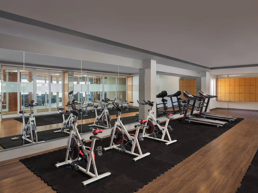 Un gimnasio con bicicletas estáticas, cintas de correr y equipo de ejercicio.