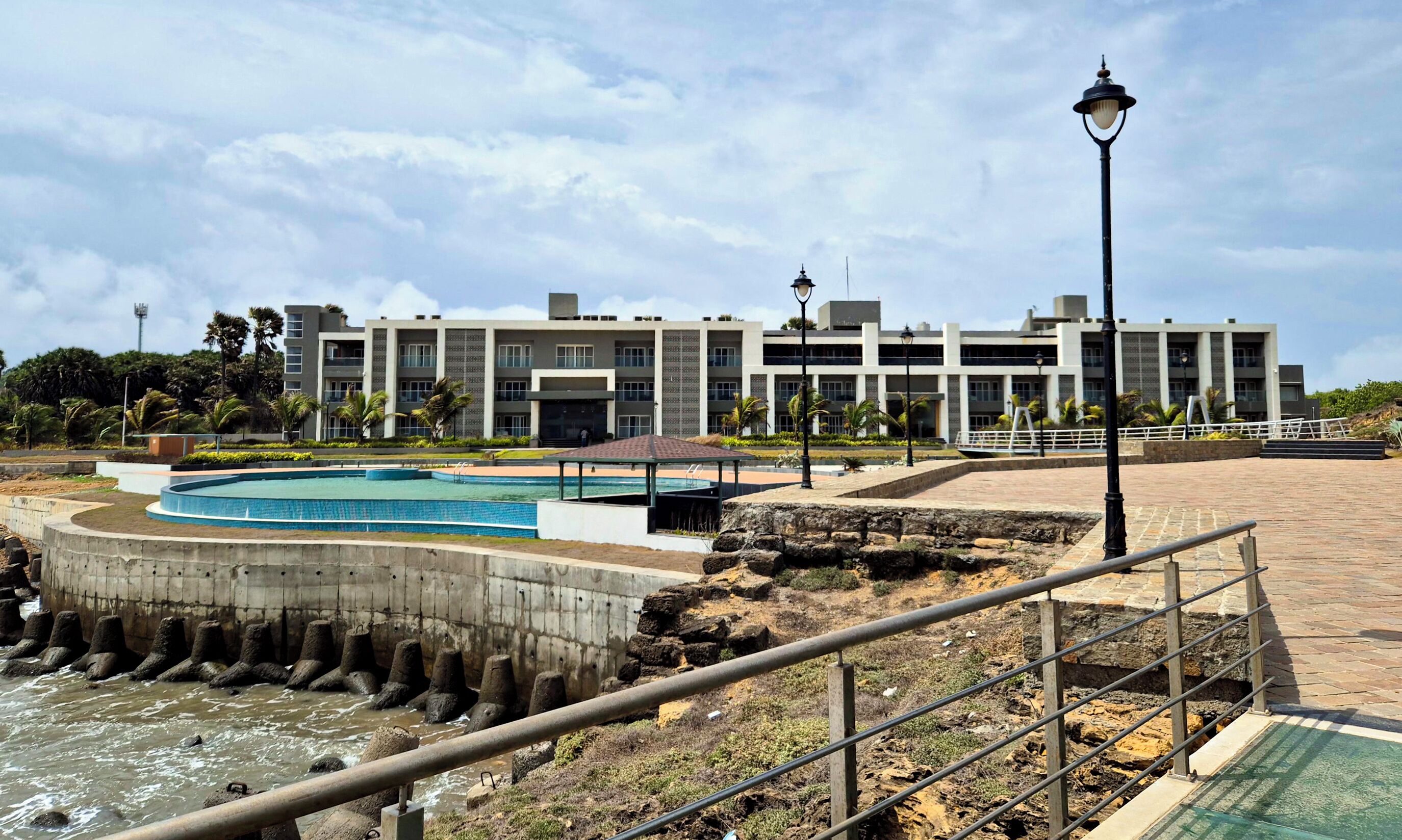 A modern building with a swimming pool and a stone retaining wall.