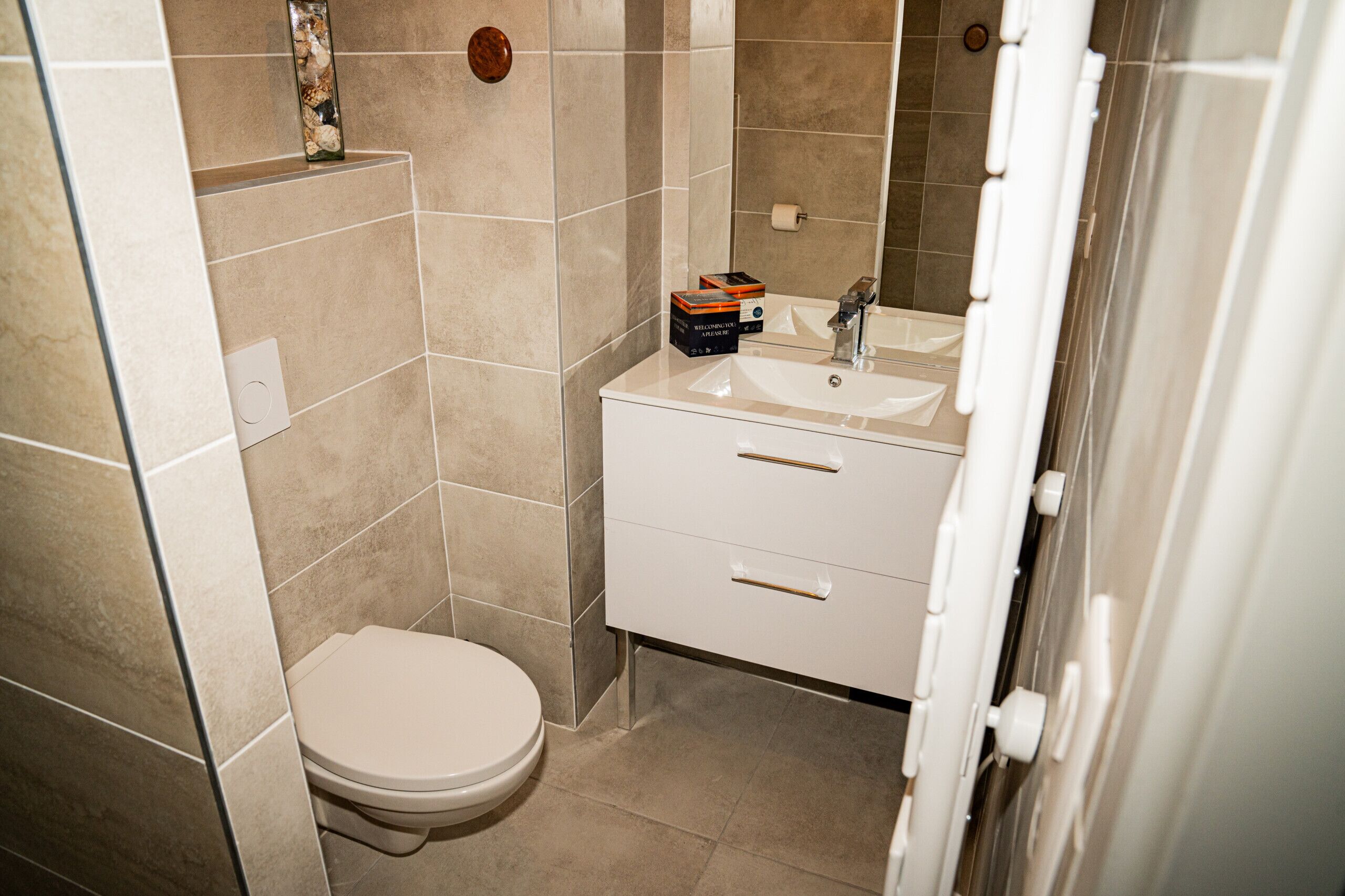 A bathroom with a toilet, a sink, and a cabinet.