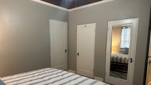A bedroom with a bed, two doors, and a closet. - Spacious 4-Bdrm house in Ruston with WiFi and AC & Wonderful front & back porch (Ruston)