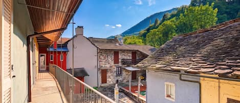 Ein Balkon mit Blick auf traditionelle Gebäude und einen Berg im Hintergrund.