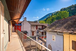 A balcony with a view of traditional buildings and a mountain in the background.